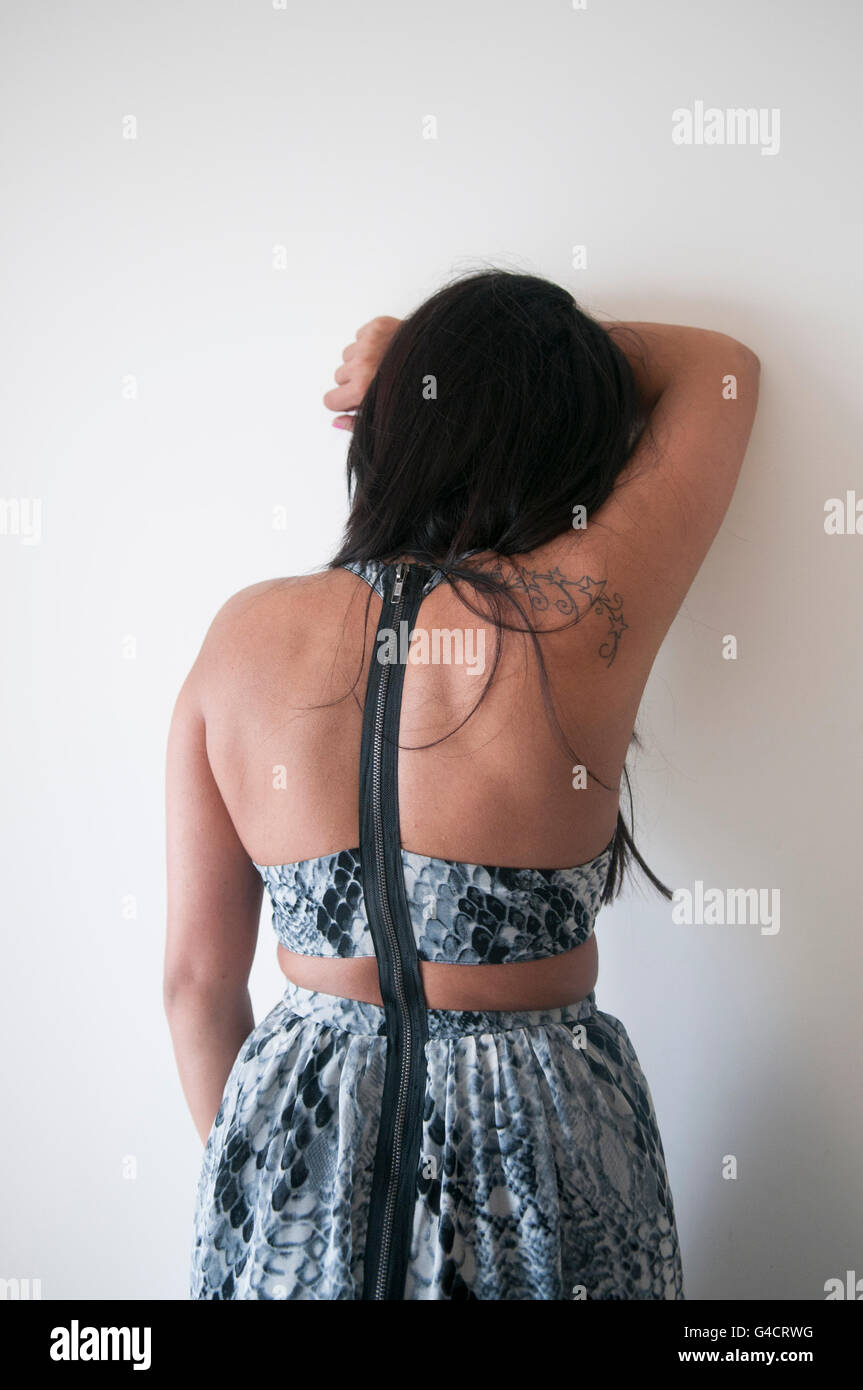 Femme triste appuyé contre le mur Banque D'Images