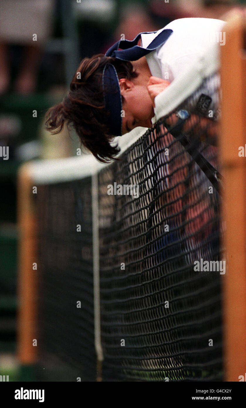 Martina Hingis, la championne en titre et la première graine, repose sa tête sur le filet alors que son affrontement de demi-finale avec Jana Novotna commence à s'éloigner d'elle à Wimbledon. Novotna a gagné le match 6-4, 6-4. Banque D'Images