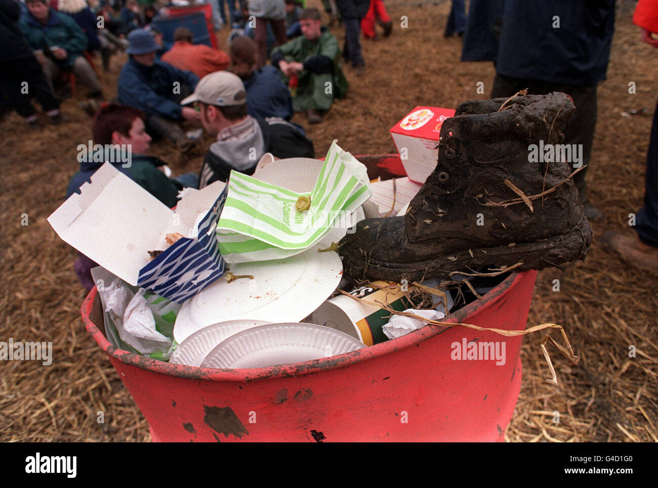 16 MAI : en ce jour de 1988, la Cour suprême des États-Unis a pour mandat que la police puisse fouiller les ordures sans mandat. Une botte boueuse est mise au rebut dans une poubelle lors du festival de Glastonbury, baigné de boue et de pluie. Banque D'Images