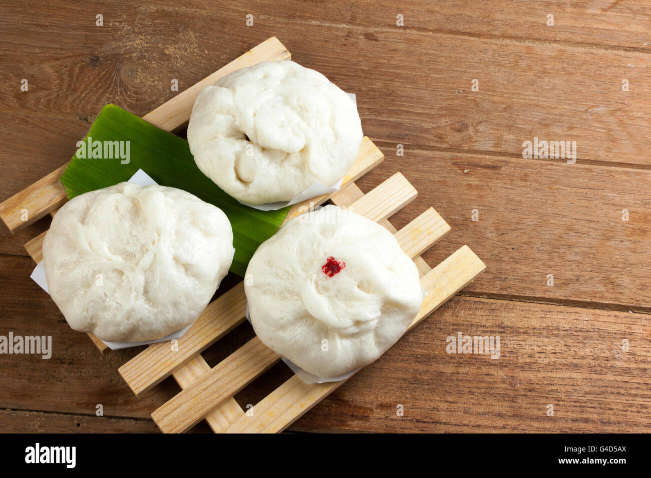 Des petits pains farcis de porc sur une plaque de bois. Banque D'Images