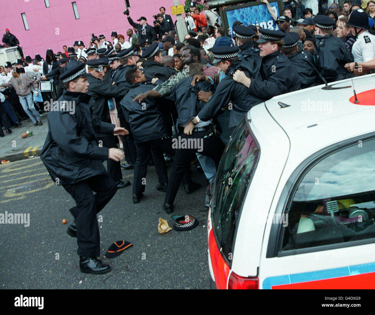 La police forme un mur autour des manifestants à l'extérieur d'Elephant and Castle alors que la camionnette transportant les suspects de meurtre de Stephen Lawrence tente de suivre la voiture de police (illustrée sur la photo) et de quitter la scène de la perturbation aujourd'hui (mardi). Voir L'ENQUÊTE sur l'histoire de l'AP Lawrence. Photo de Rosie Hallam/PA. Banque D'Images