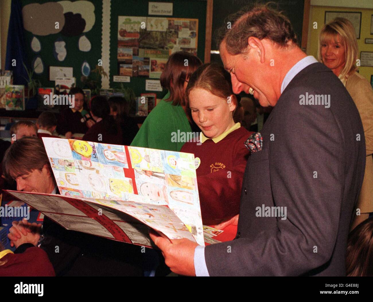 Le Prince de Galles s'intéresse beaucoup à la carte d'anniversaire du Prince Harry (qui aura 14 ans la semaine prochaine) qui lui a été remise par Vicki Moss à l'âge de 10 ans, lorsqu'il a visité l'école primaire St Marc, à Brighton cet après-midi (lundi). PHOTO DE JOHN STILLWELL/PA. Banque D'Images