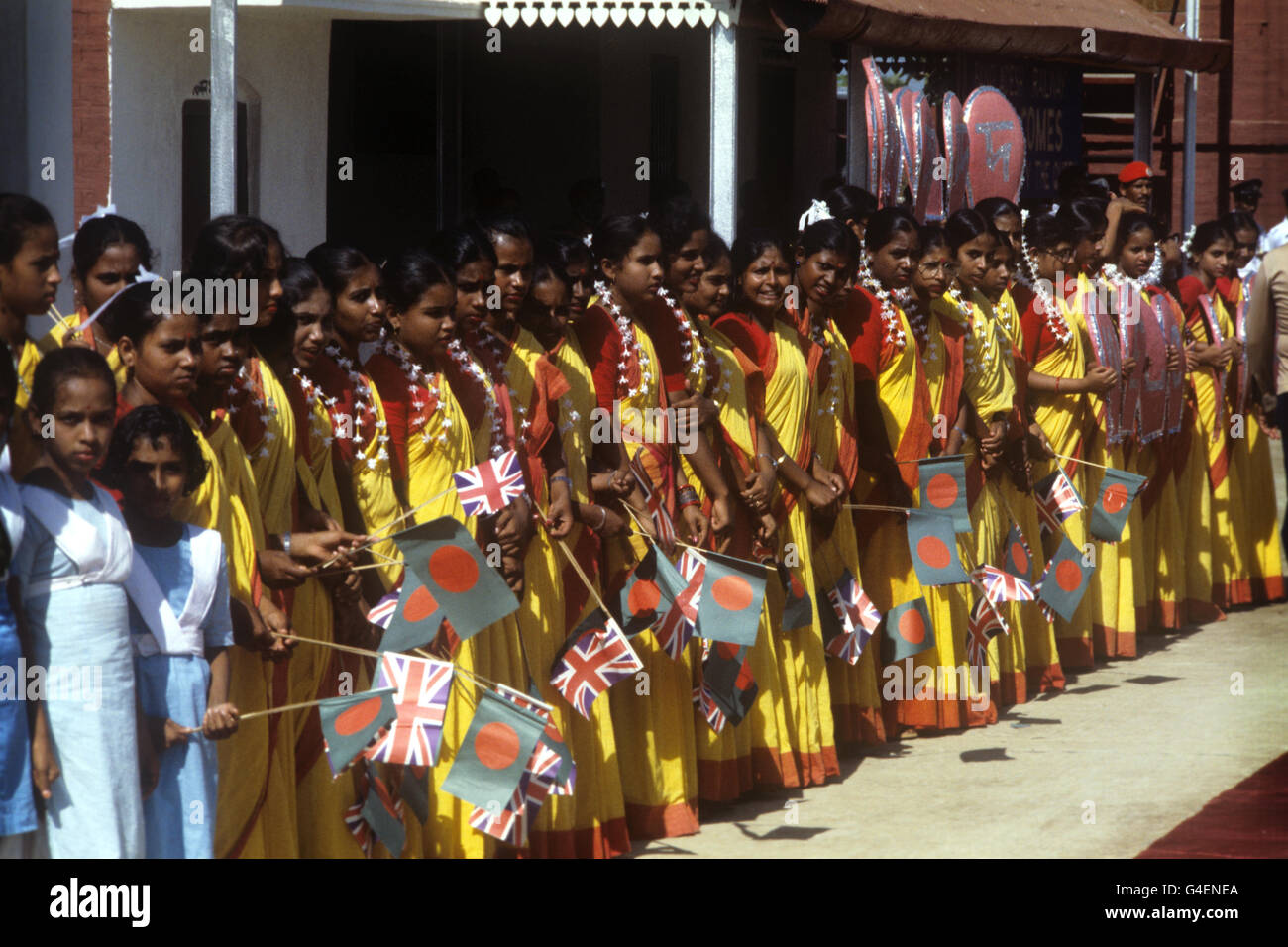 Drapeau orne les enfants à la ligne, attendant d'accueillir la Reine, lors de sa visite au Bangladesh. Banque D'Images