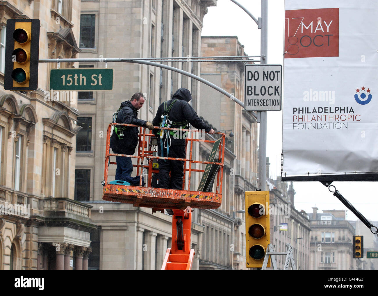 Les panneaux de signalisation et les feux de signalisation américains sont mis en place pendant que la préparation se poursuit pour le tournage de la Guerre mondiale Z à George Square, Glasgow . Banque D'Images