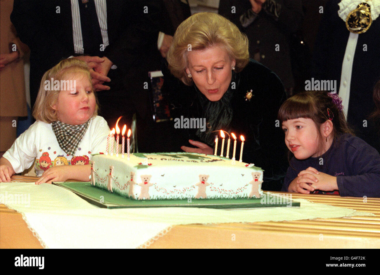 PA NEWS PHOTO 18/11/98 AIDE À LA PRINCESSE ALEXANDRA HARRIS AIMEE (L) et CHELSEA MCGONIGLE (R), les deux 6, À SOUFFLER LES BOUGIES sur un gâteau d'ANNIVERSAIRE POUR CÉLÉBRER L'ANNIVERSAIRE DE L'ÉDUCATION CONDUCTIVE DU CENTRE 10E ANNIVERSAIRE, LORS DE SA VISITE AU CENTRE DU WEST END, Londres. Le centre pratique le système le PETO POUR LES ENFANTS ATTEINTS de paralysie cérébrale. Banque D'Images