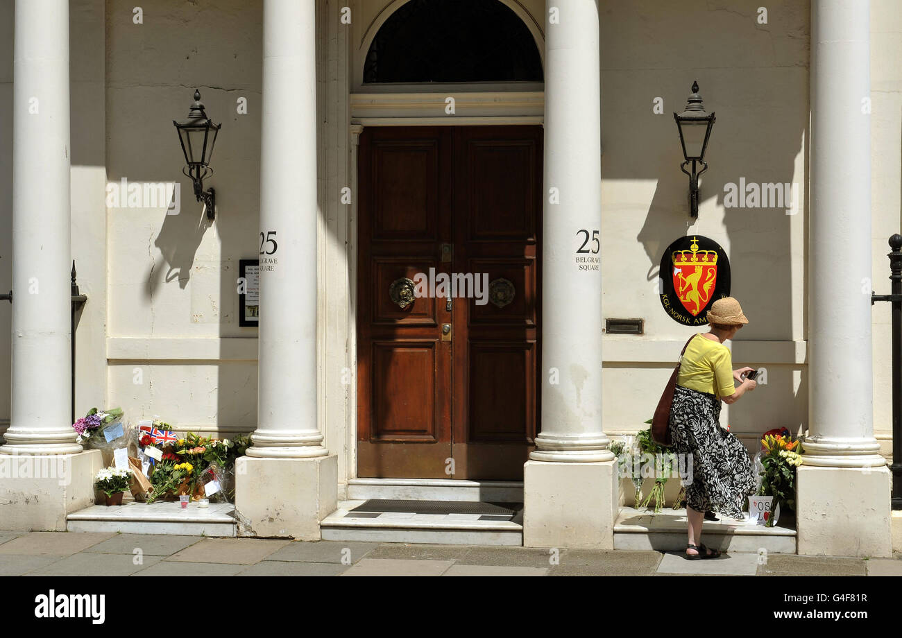Une femme prend une photo des fleurs et des messages laissés à l'extérieur de l'ambassade royale norvégienne, dans le centre de Belgravia, à la suite des attaques jumelles qui ont eu lieu vendredi à Oslo en Norvège. Banque D'Images Une femme prend une photo des fleurs et des messages laissés à l'extérieur de l'ambassade royale norvégienne, dans le centre de Belgravia, à la suite des attaques jumelles qui ont eu lieu vendredi à Oslo en Norvège. Banque D'Images