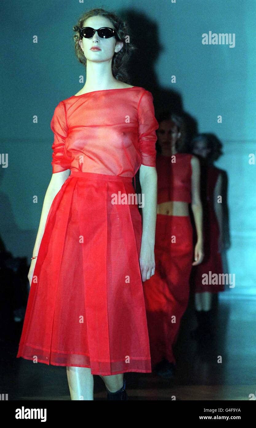 Un mannequin porte un haut en mousseline rouge transparent avec une jupe plissée assortie de la collection Justin Oh lors de la London Fashion week Today (vendredi).Photo de Neil Munns/PA Banque D'Images