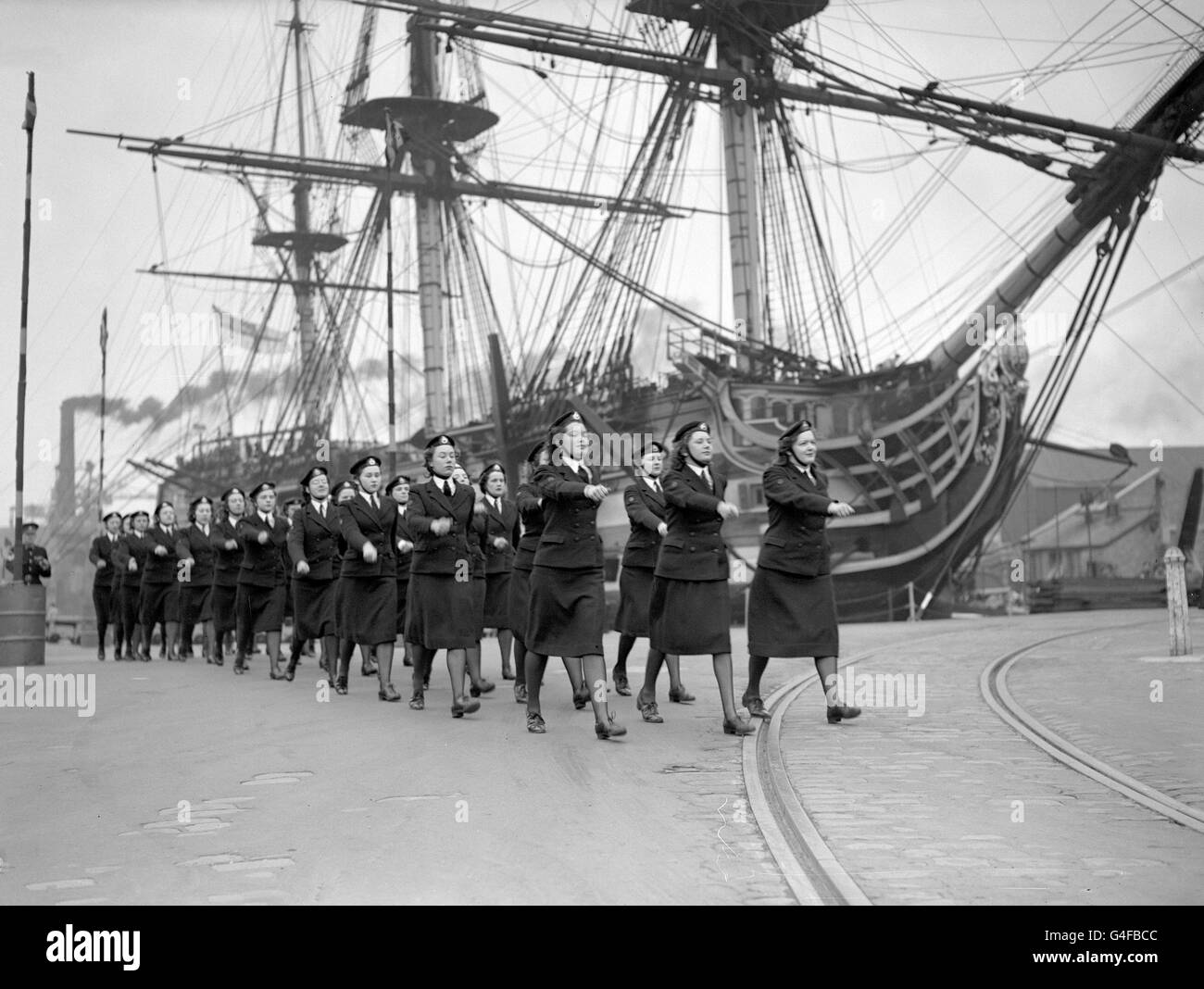 Avec la victoire du HMS en arrière-plan, Wrens de la Royal Marine Barracks, Eastney, répète pour l'exposition de forages que le Service Royal naval féminin doit donner dans le cadre du programme des Portsmouth Navy Days. Banque D'Images