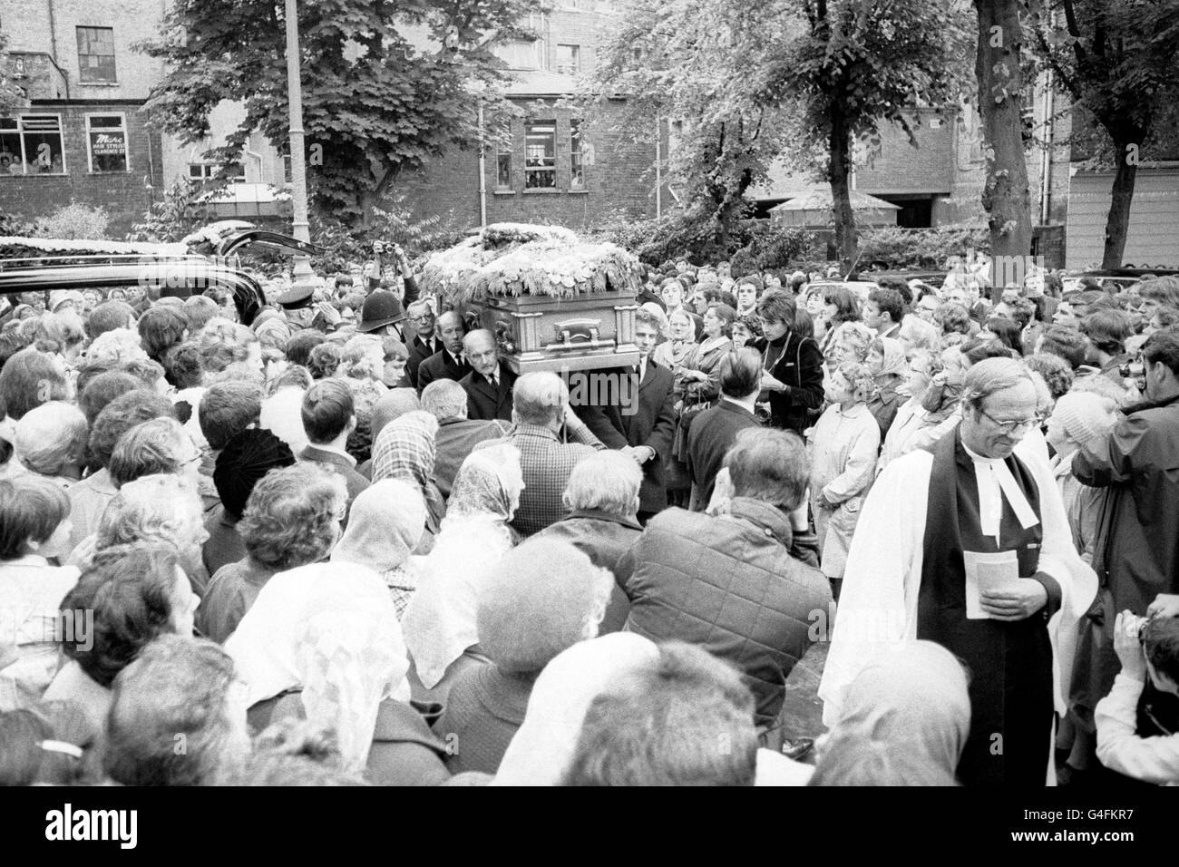 Les foules regardent le cercueil arriver à l'église paroissiale de Cheltenham pour le service funéraire de Brian Jones, ancien guitariste de 27 ans avec les Rolling Stones. Banque D'Images