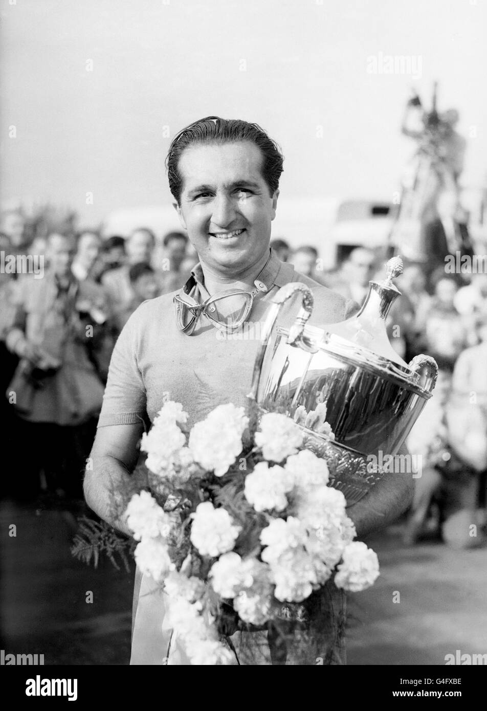 Courses automobiles - International Trophy Meeting - Silverstone.Le vainqueur Alberto Ascari tient le trophée et un bouquet après avoir revendiqué la victoire dans sa Ferrari Banque D'Images