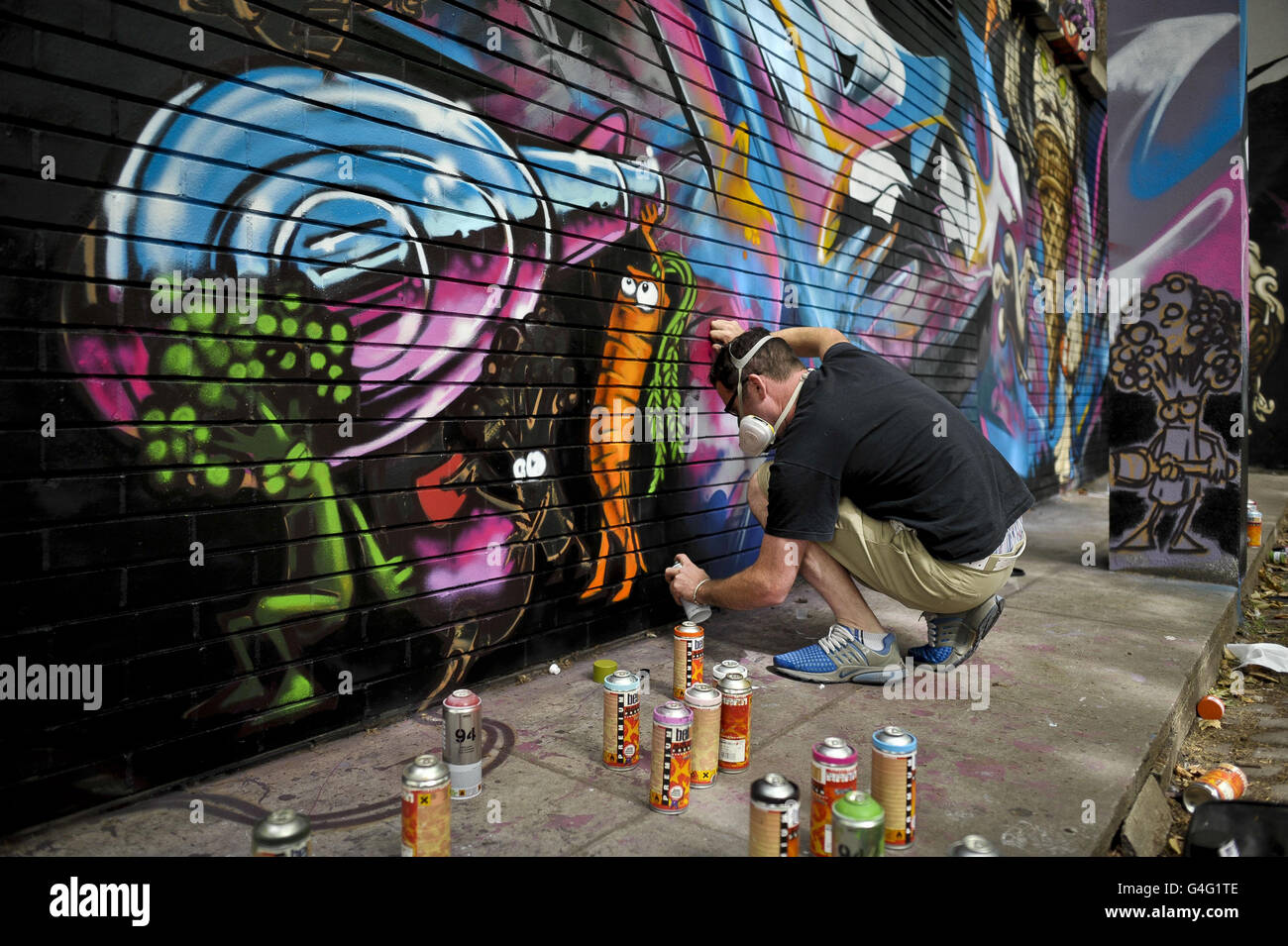 Un graffiti peint un morceau d'art de rue sur Nelson Street, Bristol, où se déroule le plus grand projet d'art de rue du Royaume-Uni, « voir No Evil ». Banque D'Images