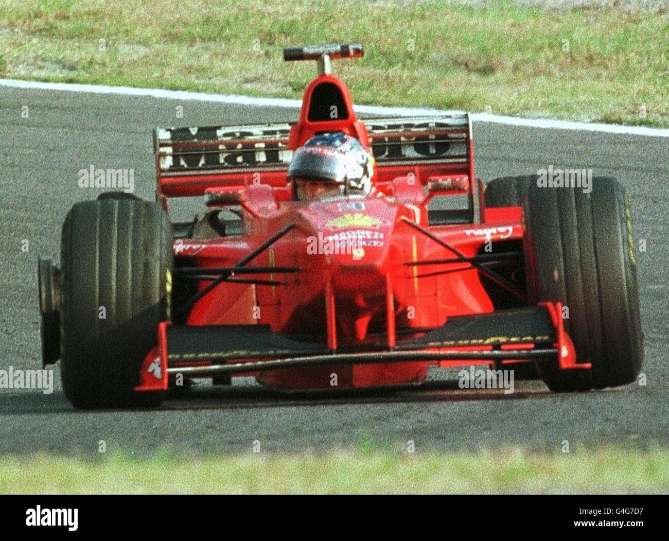 L'allemand pilote de F1 Michael Schumacher de l'Ferrari revient en tant que son pneu arrière droit éclate dans le 32e tour de la Formule Un Grand Prix du Japon à Suzuka 01 novembre. Quatre concurrents points derrière Mika Hakkinen de Finlande, Schumacher a pris sa retraite de la course. PA NEWS PHOTO Banque D'Images