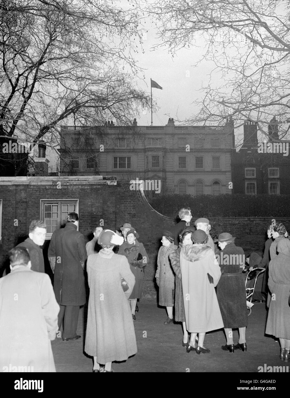 Les Londoniens regardent le Standard du souverain se flairer sur Clarence House pour la première fois après le retour si la nouvelle reine Elizabeth II et son mari, le duc d'Édimbourg. Le couple royal venait de rentrer du Kenya après la mort du roi George VI Banque D'Images