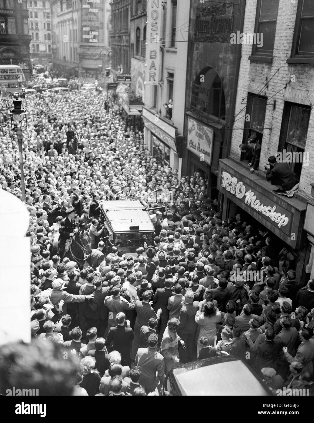 Alors que la foule s'emboîte dans Windmill Street, Londres, le challenger britannique Randolph Turpin se met à prendre un taxi pour entrer dans le gymnase de Jack Solomon pour le match de ce soir contre le détenteur du titre Sugar Ray Robinson Banque D'Images Alors que la foule s'emboîte dans Windmill Street, Londres, le challenger britannique Randolph Turpin se met à prendre un taxi pour entrer dans le gymnase de Jack Solomon pour le match de ce soir contre le détenteur du titre Sugar Ray Robinson Banque D'Images