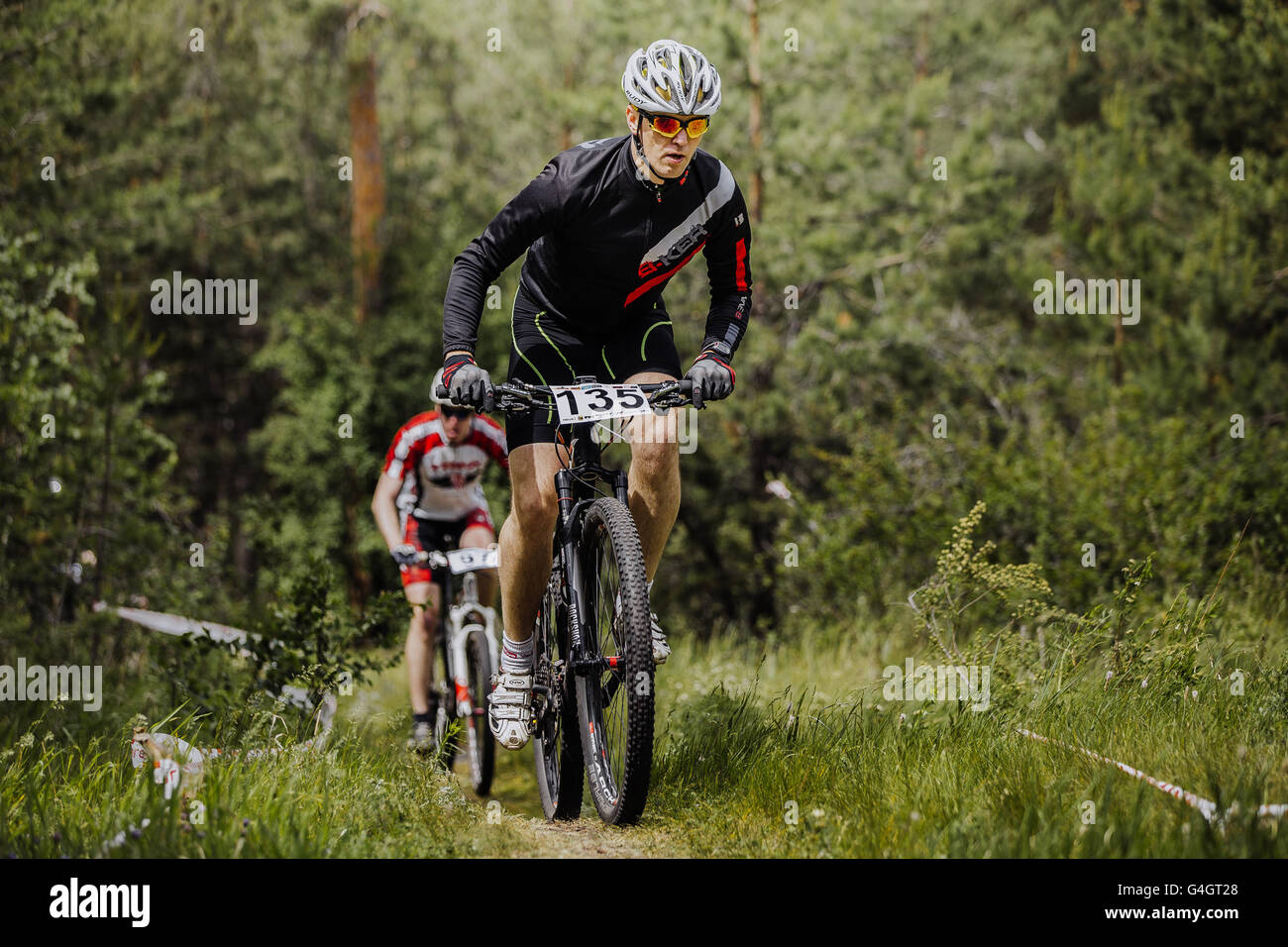 Deux hommes athlètes cyclist montée en forêt en course cross-country de l'énergie 'Nouveau' Banque D'Images