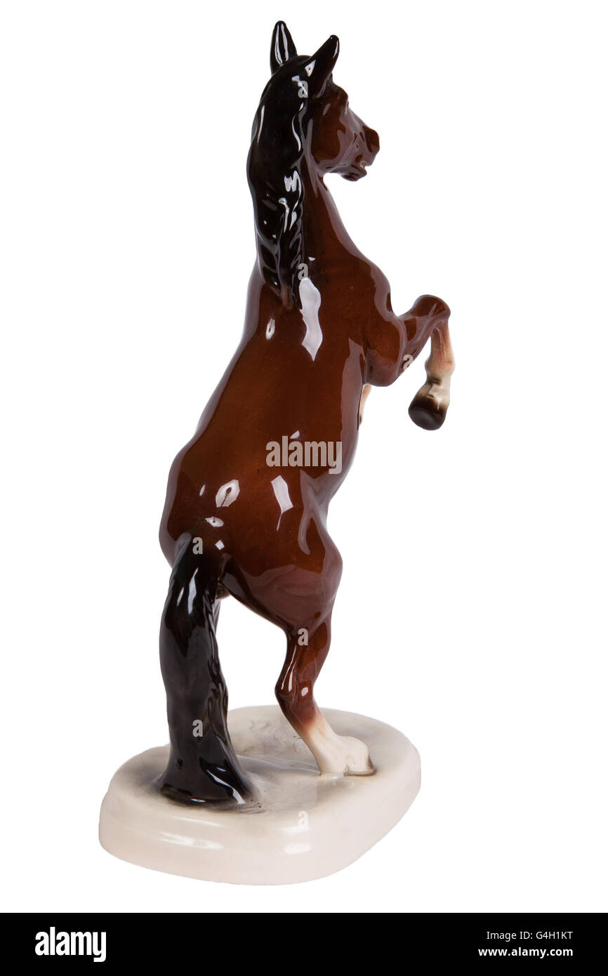 Figurine en céramique marron d'un cheval sur un fond blanc Banque D'Images