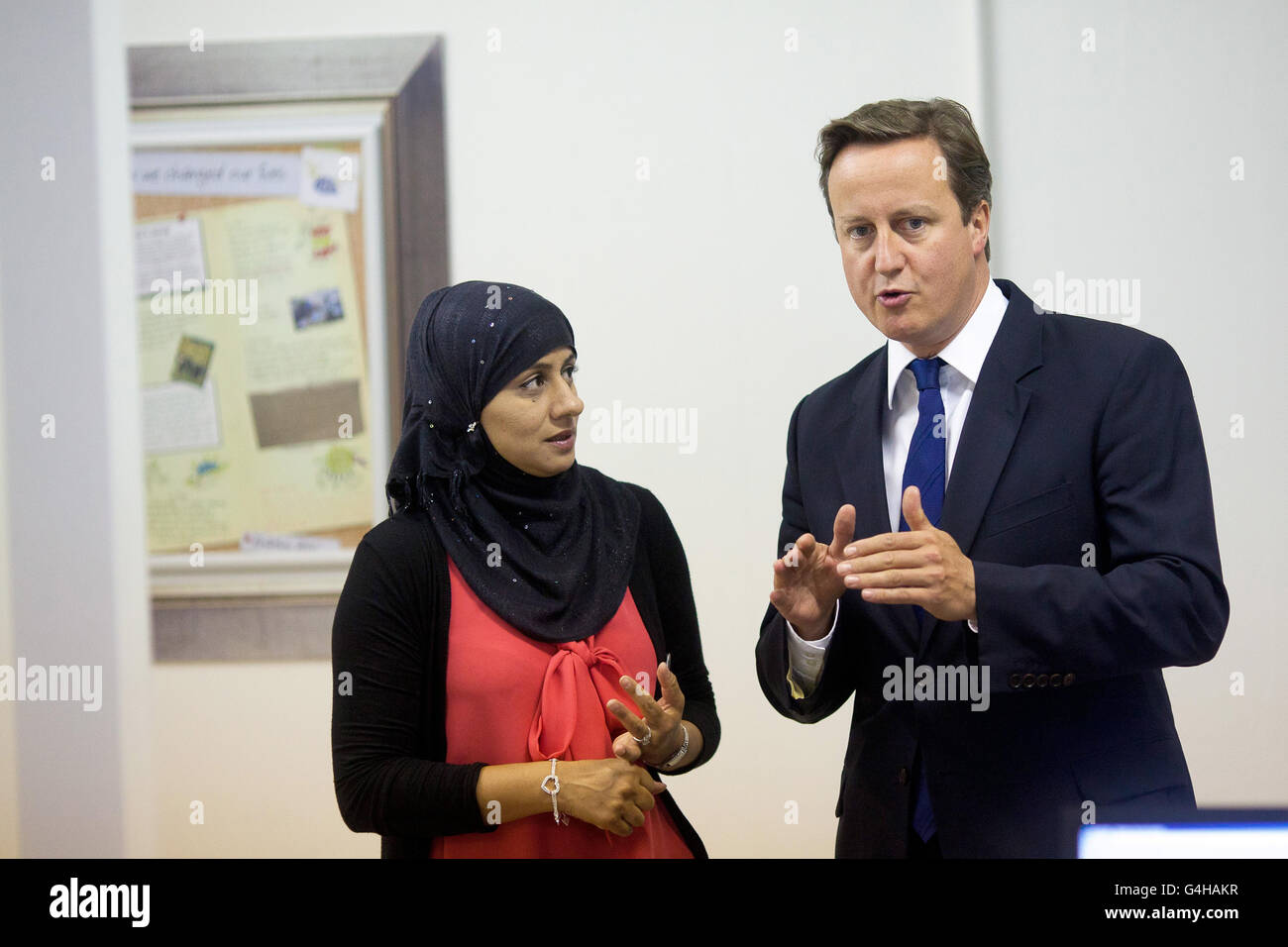 Le Premier ministre David Cameron s'entretient avec Shahida DIN lors d'une visite aux bureaux de l'A4E (action pour l'emploi) à Brixton, dans le sud de Londres. Banque D'Images