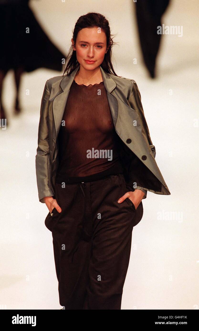 Un mannequin porte un haut marron diaphane et un pantalon avec une veste grise lors du spectacle automne/hiver de Betty Jackson au Musée d'histoire naturelle de Londres dans le cadre de la Fashion week de Londres. Banque D'Images