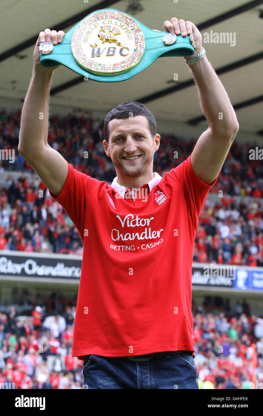 Carl Froch, champion du monde, porte son maillot de la forêt de Nottingham, montre sa ceinture WBC à la foule lors du match du championnat de npower au City Ground, à Nottingham. Banque D'Images