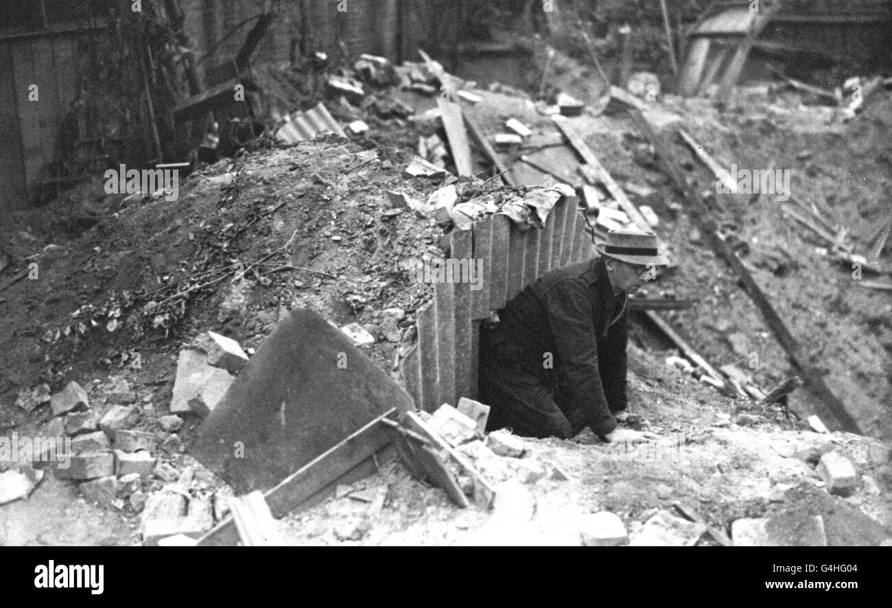 Les dommages causés par un avion allemand dans une ville côtière du sud de l'Angleterre montrent un cratère à côté d'un abri Anderson, dont les occupants ont été sans danger. Banque D'Images