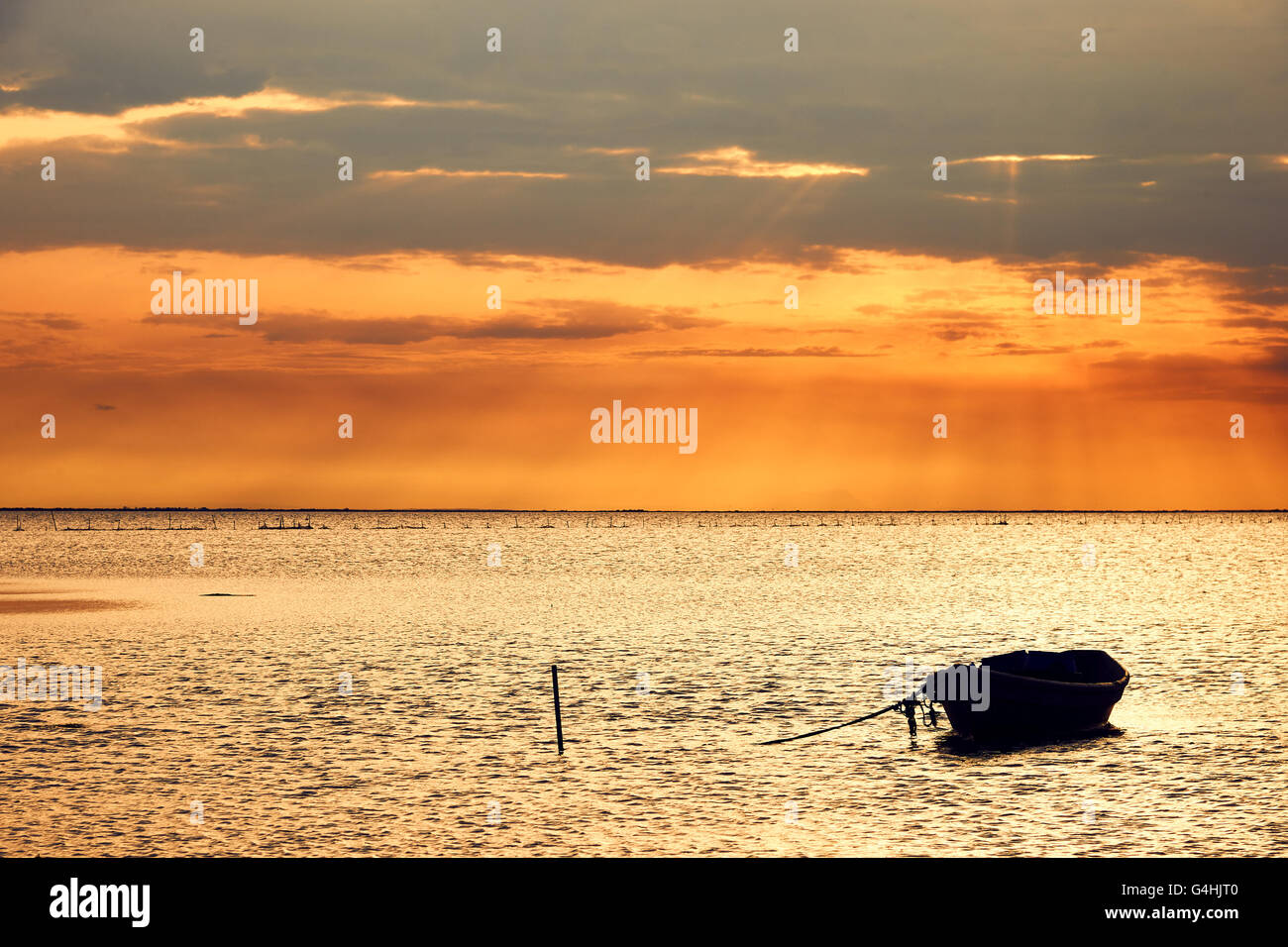 Bellissimo paesaggio marino con una barca ancorata, fotografato all'alba en Camargue Banque D'Images