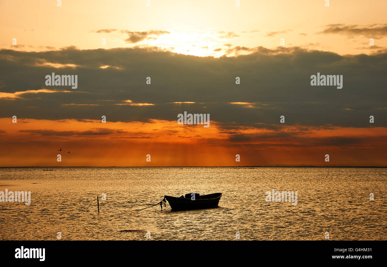 Bellissimo paesaggio marino con una barca ancorata, fotografato all'alba en Camargue Banque D'Images