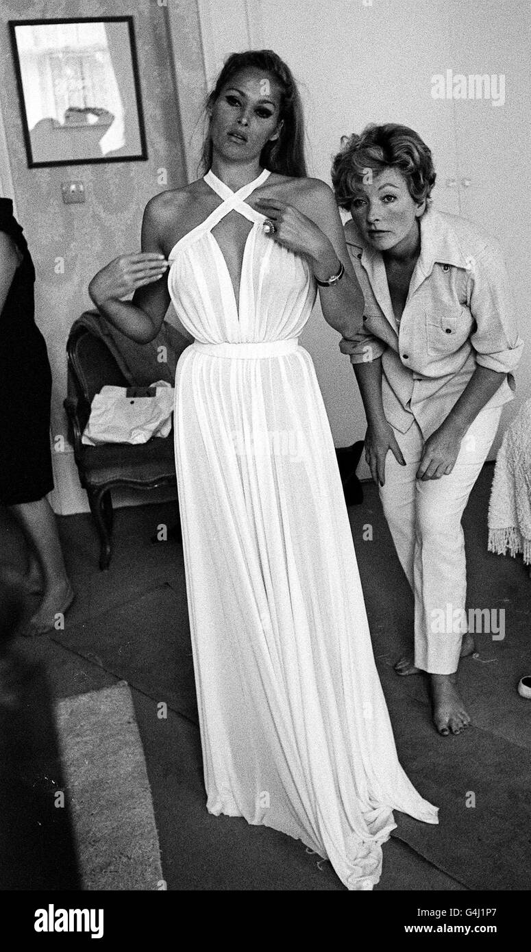 L'actrice Ursula Andress essaie une robe en mousseline, conçue par Julie Harris (à droite), pour une séquence dans le film James Bond 'Casino Royale'. Banque D'Images L'actrice Ursula Andress essaie une robe en mousseline, conçue par Julie Harris (à droite), pour une séquence dans le film James Bond 'Casino Royale'. Banque D'Images