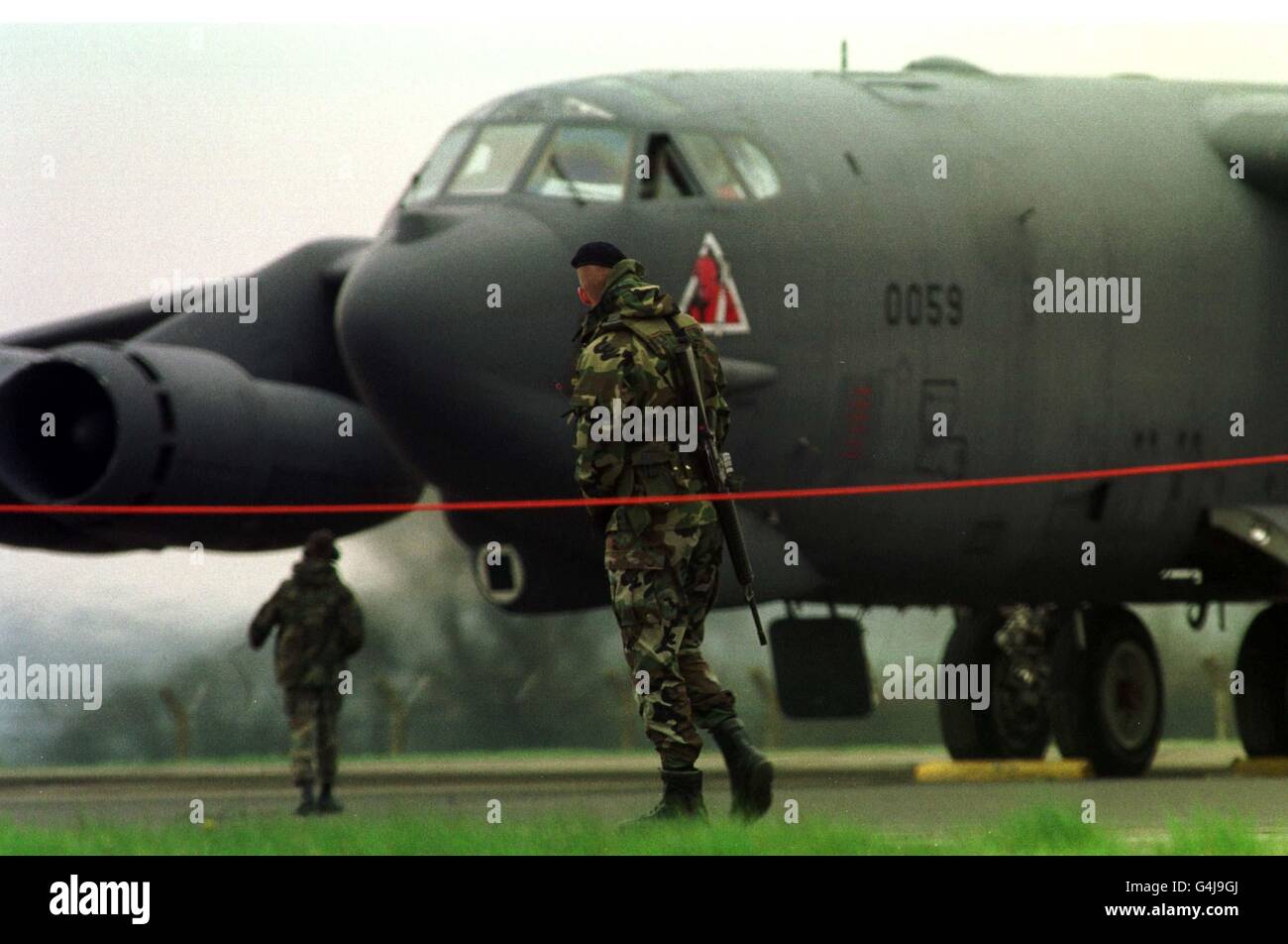 Un sentinelle armé de l'armée de l'air américaine effectue des patrouilles devant un bombardier B-52 de l'armée de l'air américaine qui se prépare à partir de la RAF Fairford, le lendemain de l'ordre donné par le secrétaire général de l'OTAN, Javier Solana, de frappes aériennes punitives contre des cibles d'un pianiste serbe dans toute la Yougoslavie. Banque D'Images