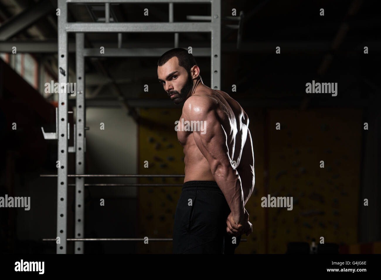 Portrait d'un jeune homme en montrant le triceps côté musculaire - Fitness Model Posing Bodybuilder athlétiques exercices après Banque D'Images