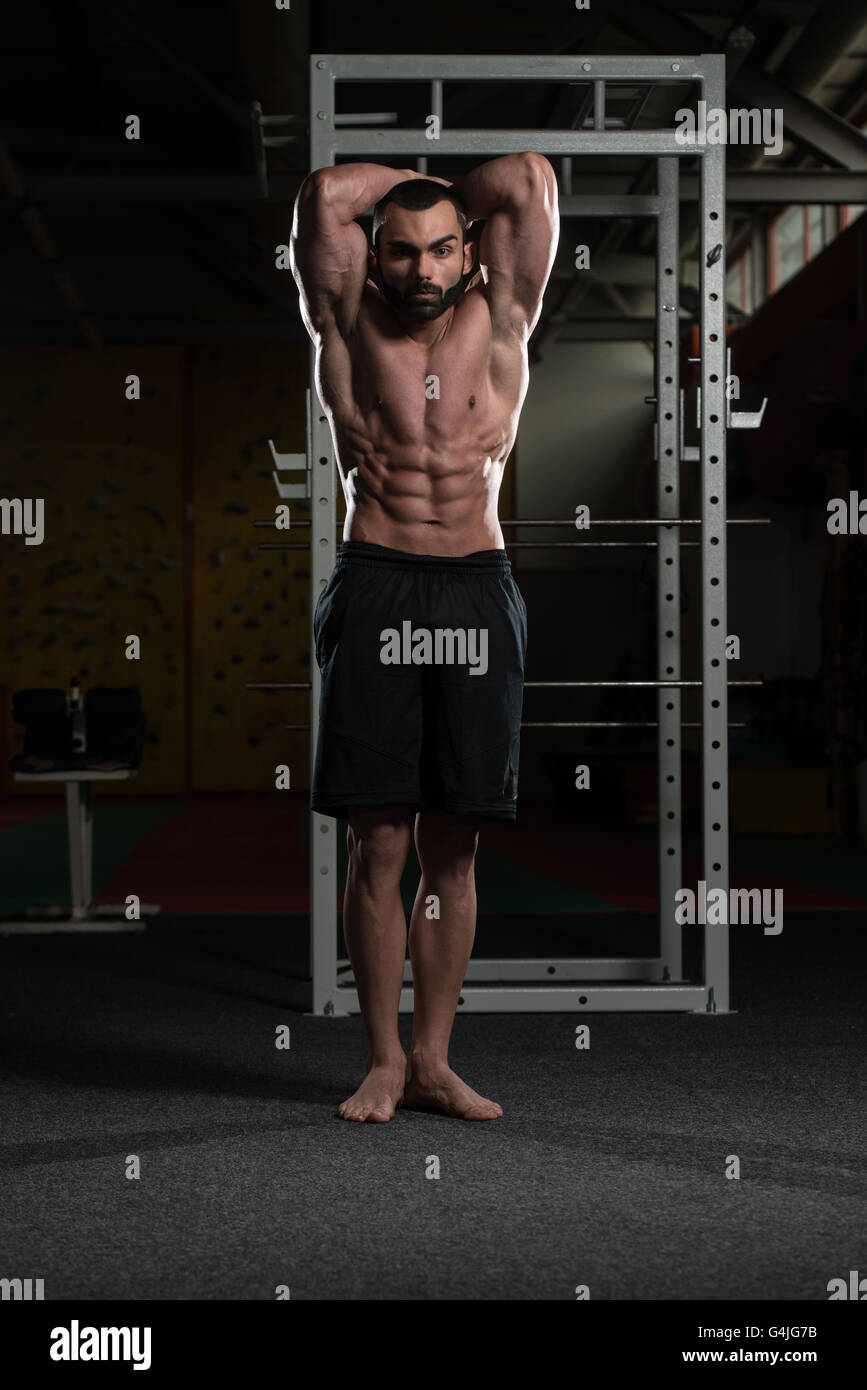 Portrait d'un jeune homme en bonne forme physique montrant ses muscles abdominaux bien formés - Modèle de remise en forme musculaire Bodybuilder athlétique Banque D'Images