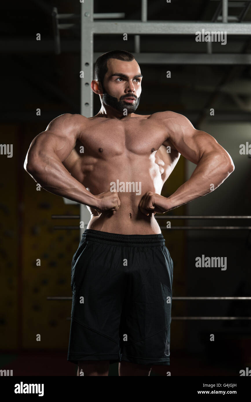 Portrait d'un jeune homme en Scène Lat propagation poser - Remise en forme musculaire Bodybuilder Athletic Model Posing après l'exercice Banque D'Images
