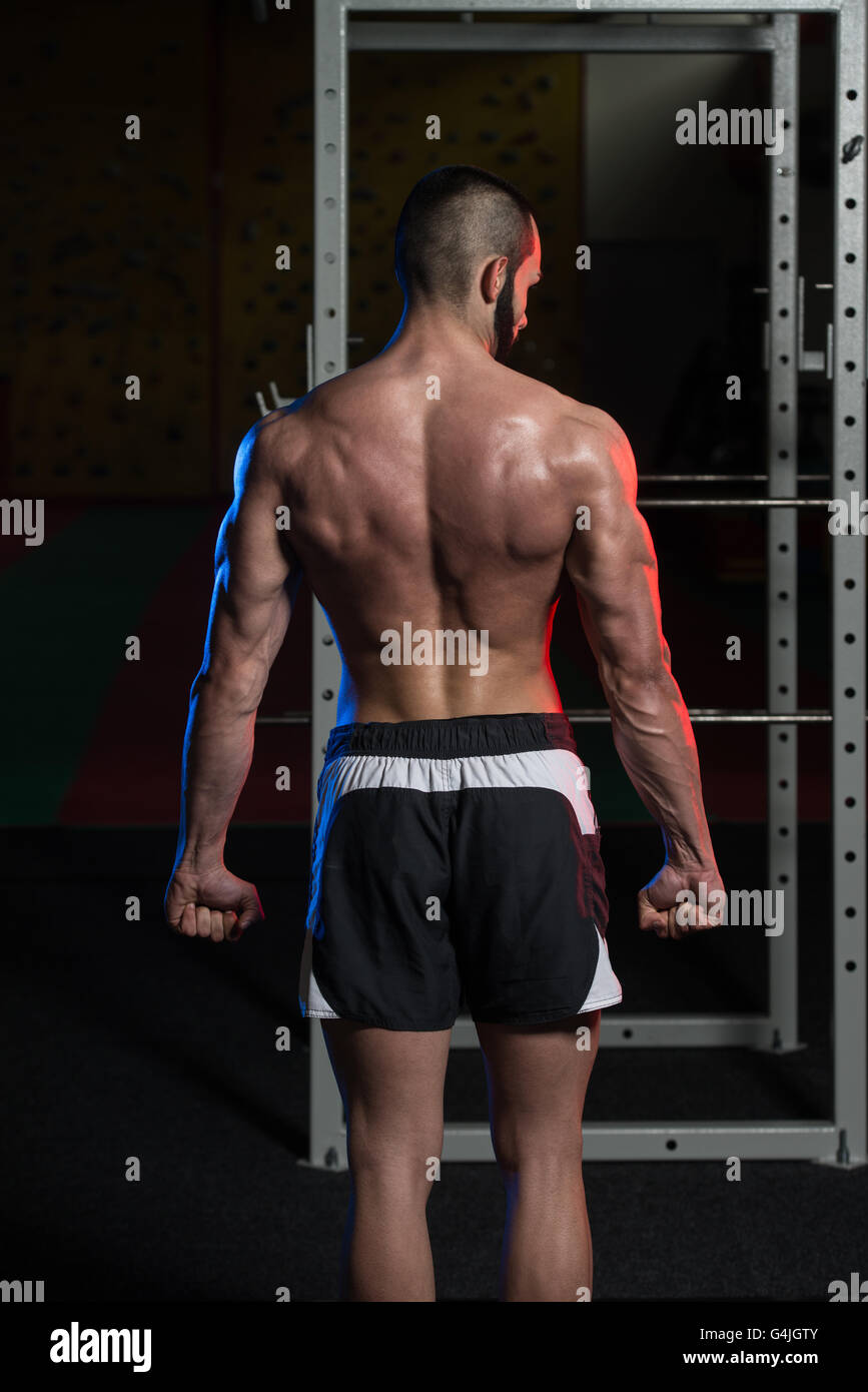 Portrait d'un jeune homme en montrant le triceps côté musculaire - Fitness Model Posing Bodybuilder athlétiques exercices après Banque D'Images