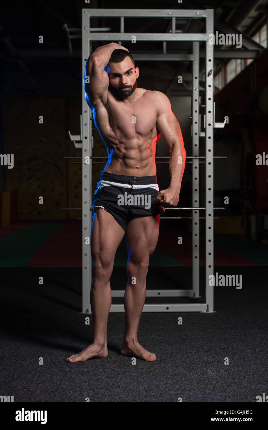 Portrait d'un jeune homme en bonne forme physique montrant ses muscles abdominaux bien formés - Modèle de remise en forme musculaire Bodybuilder athlétique Banque D'Images