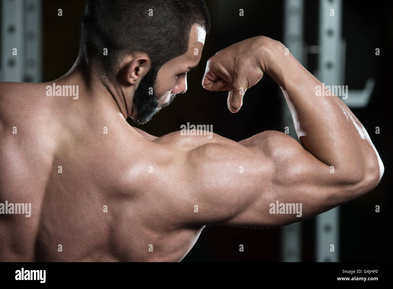 Portrait of a Young Man Flexing Biceps avant fit poser - Athletic musculaire Fitness Model Posing Bodybuilder Exercices après Banque D'Images