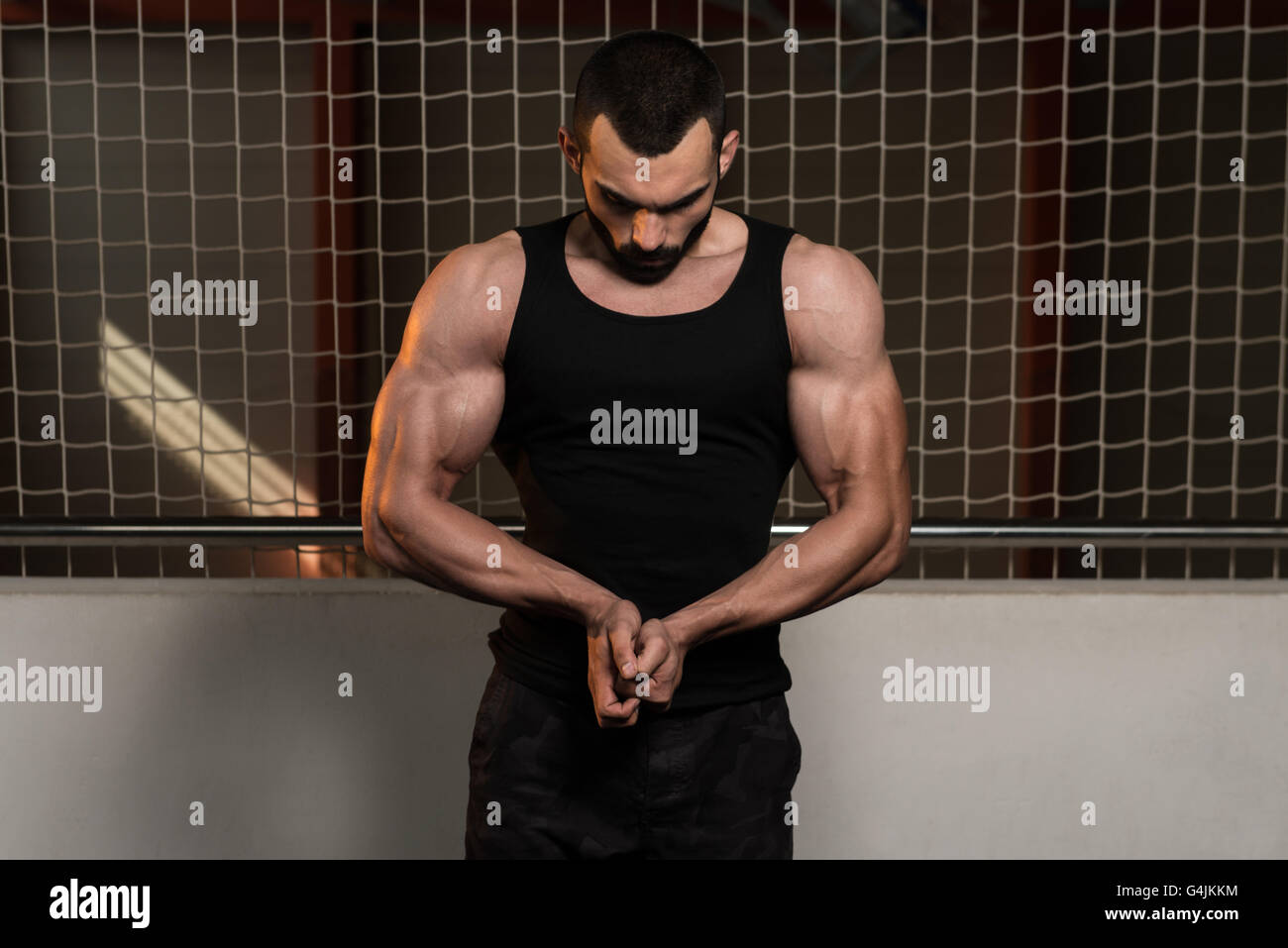 Portrait d'un jeune homme en montrant son corps bien formé dans le réservoir - Remise en forme musculaire Bodybuilder Athletic Model Posing Après Exe Banque D'Images