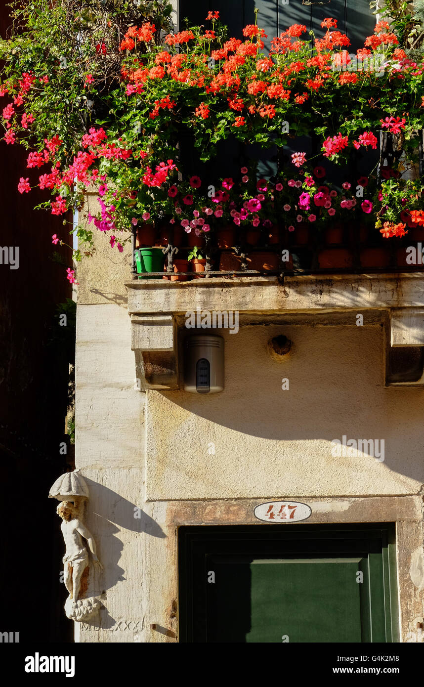 Balcon couvert de fleurs rouges à Venise Italie Banque D'Images