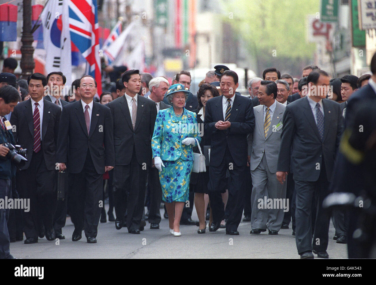La Reine Elizabeth II est flanquée de gardes de sécurité tout en marchant dans l'Insadong, une rue commerçante traditionnelle, à Séoul le deuxième jour de sa visite en Corée du Sud. Banque D'Images