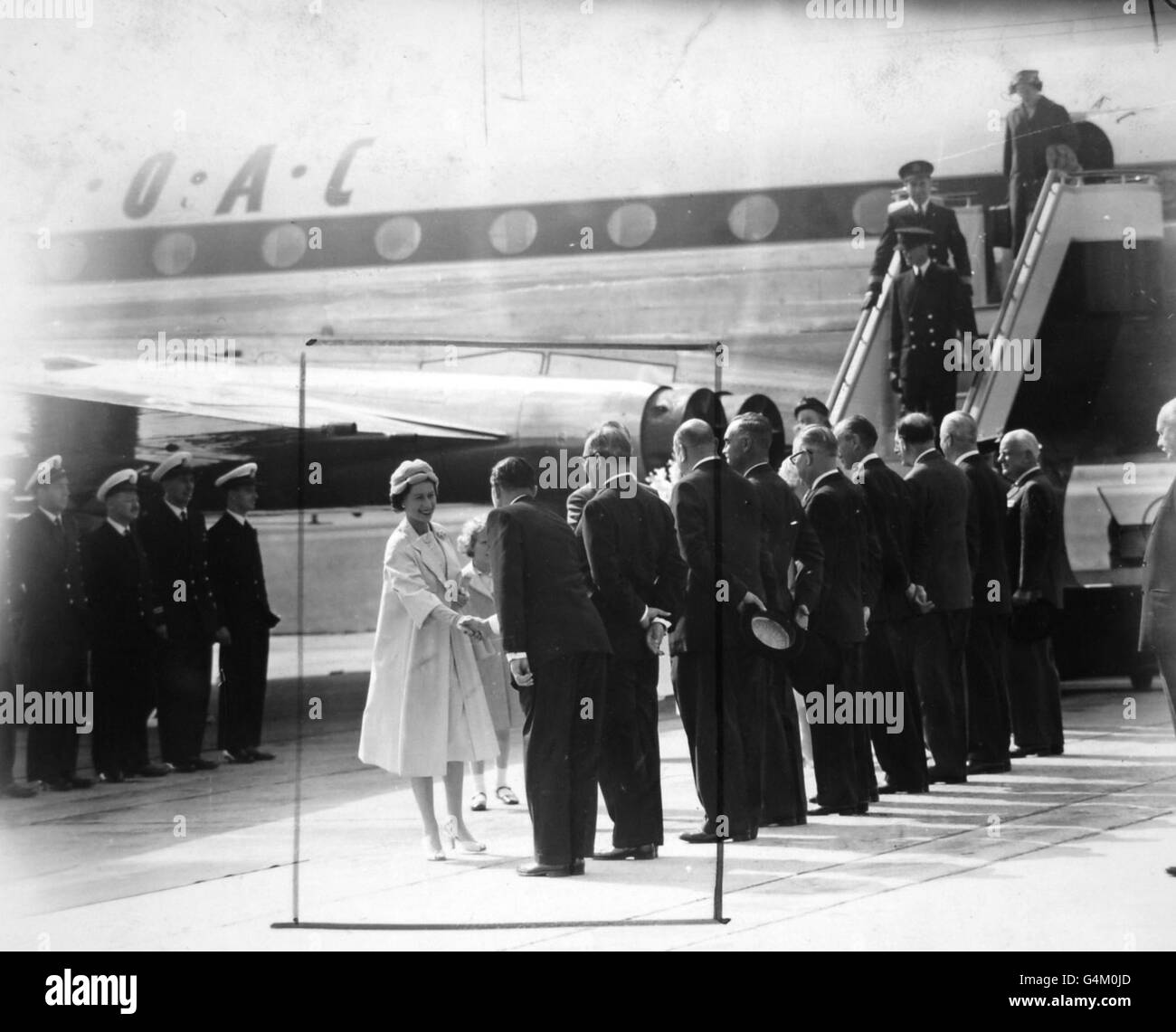 **a scanné basse résolution hors contact** la Reine serre la main avec les membres du comité officiel de réception à l'aéroport d'Heathrow, après son vol du Canada et la tournée royale. Banque D'Images