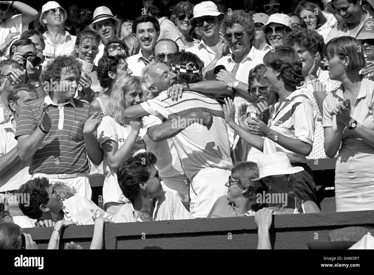 Pat Cash, champion de Wimbledon, épouse son entraîneur Ian Barclay, comme sa petite amie Anne-Britt (L) regarde, tandis que l'australien euphorique célèbre sa victoire. Banque D'Images