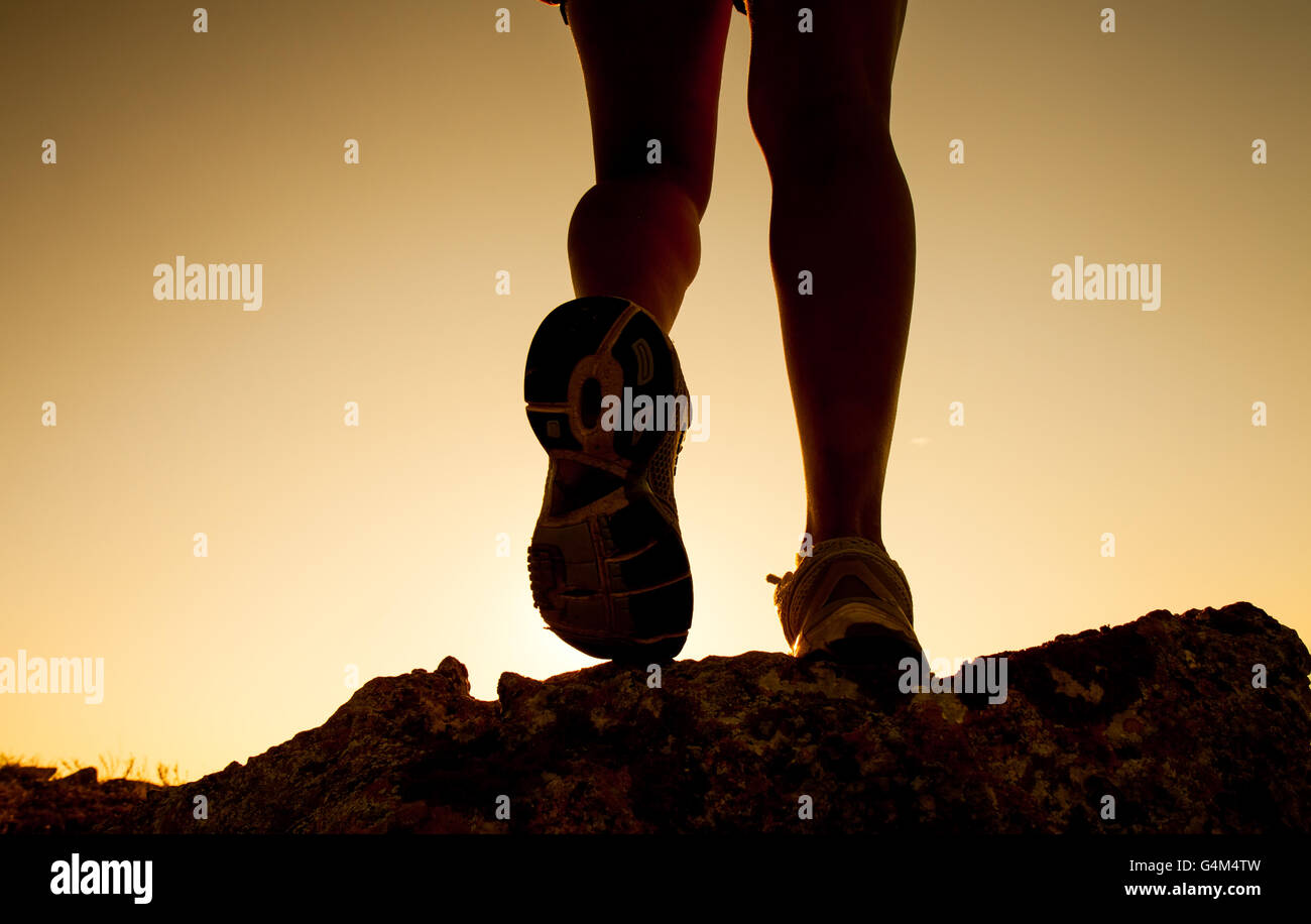 Silhouette de fitness petite fille jambes tournant au coucher du soleil Banque D'Images