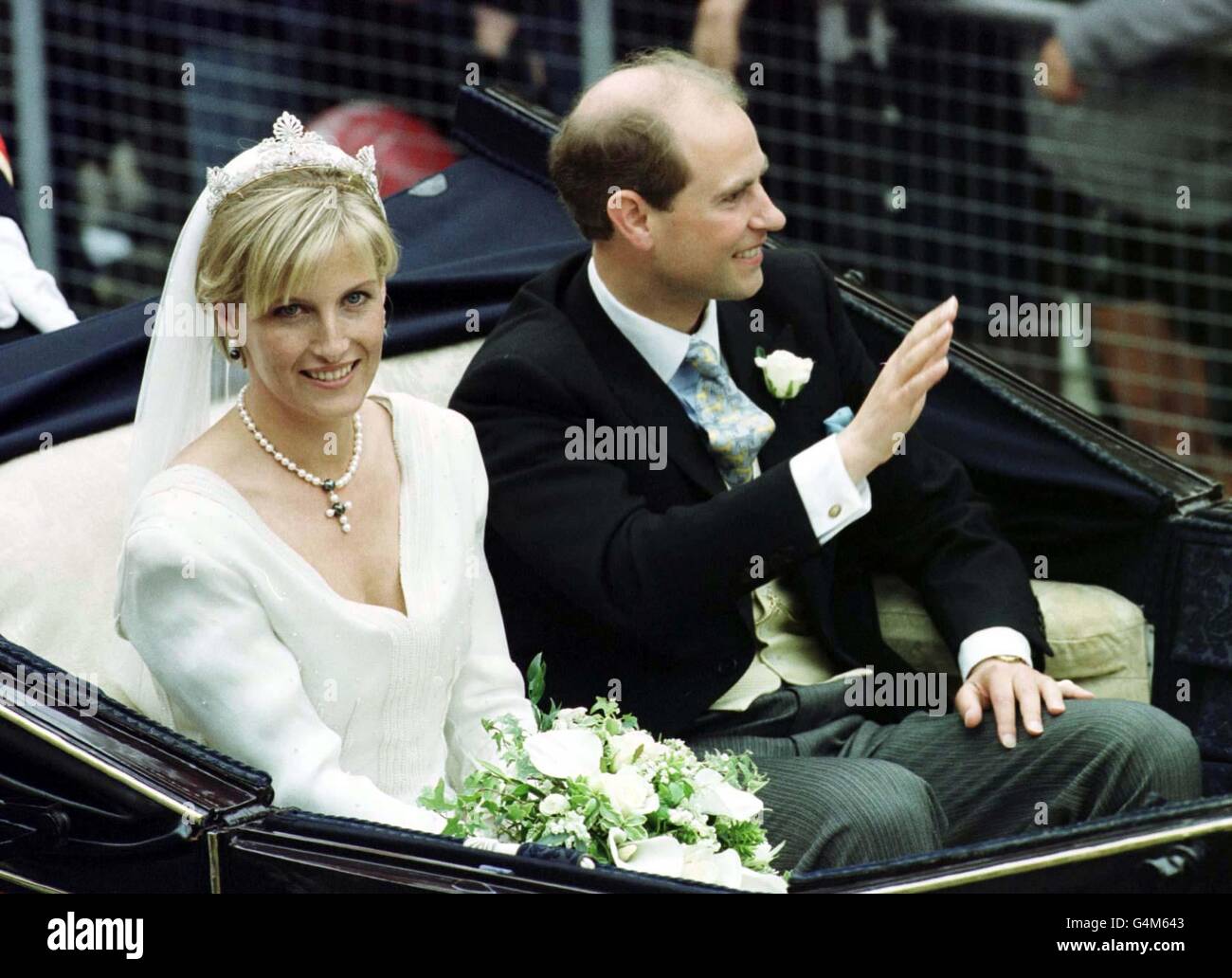 Le Prince Edward se déferle devant de la foule alors qu'il quitte la chapelle Saint-George à Windsor avec sa mariée Sophie Rhys-Jones. Le couple royal, qui s'est réuni lors d'un match de tennis organisé par le Prince, sera ensuite connu sous le nom de comte et comtesse de Wessex. Banque D'Images
