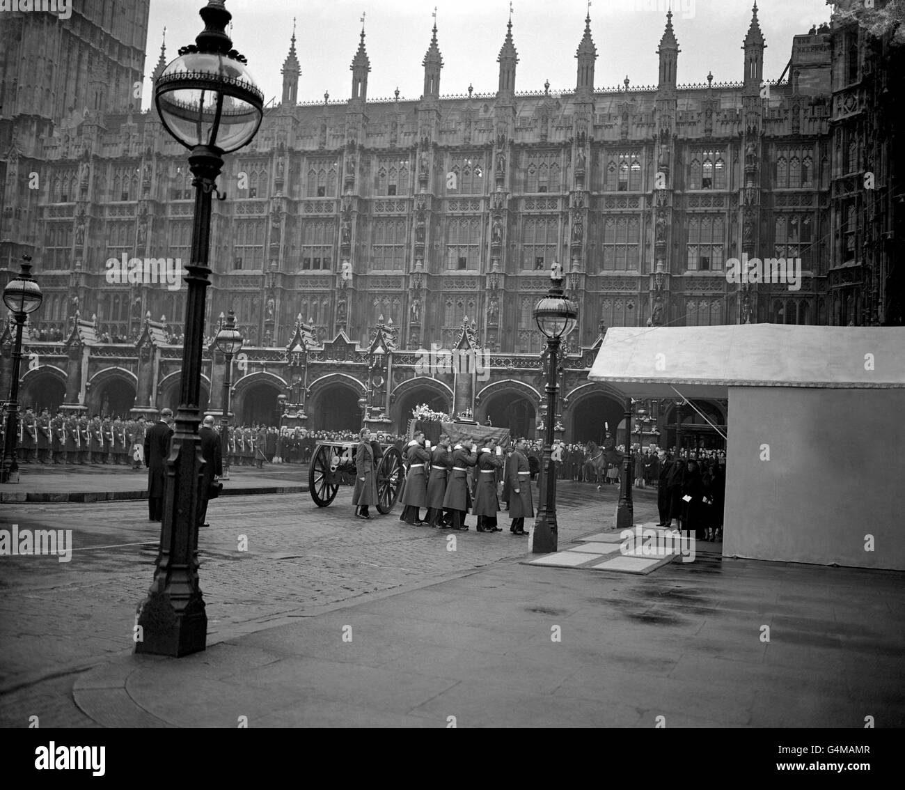 Les membres de la Compagnie du Roi, Grenadier Guards, transportent le cercueil du Roi George VI dans le Westminster Hall, pour les personnes qui se trouvent dans l'État.Sous la canopée se trouvent, de gauche à droite, la reine Elizabeth II, la reine Marie et la reine mère. Banque D'Images