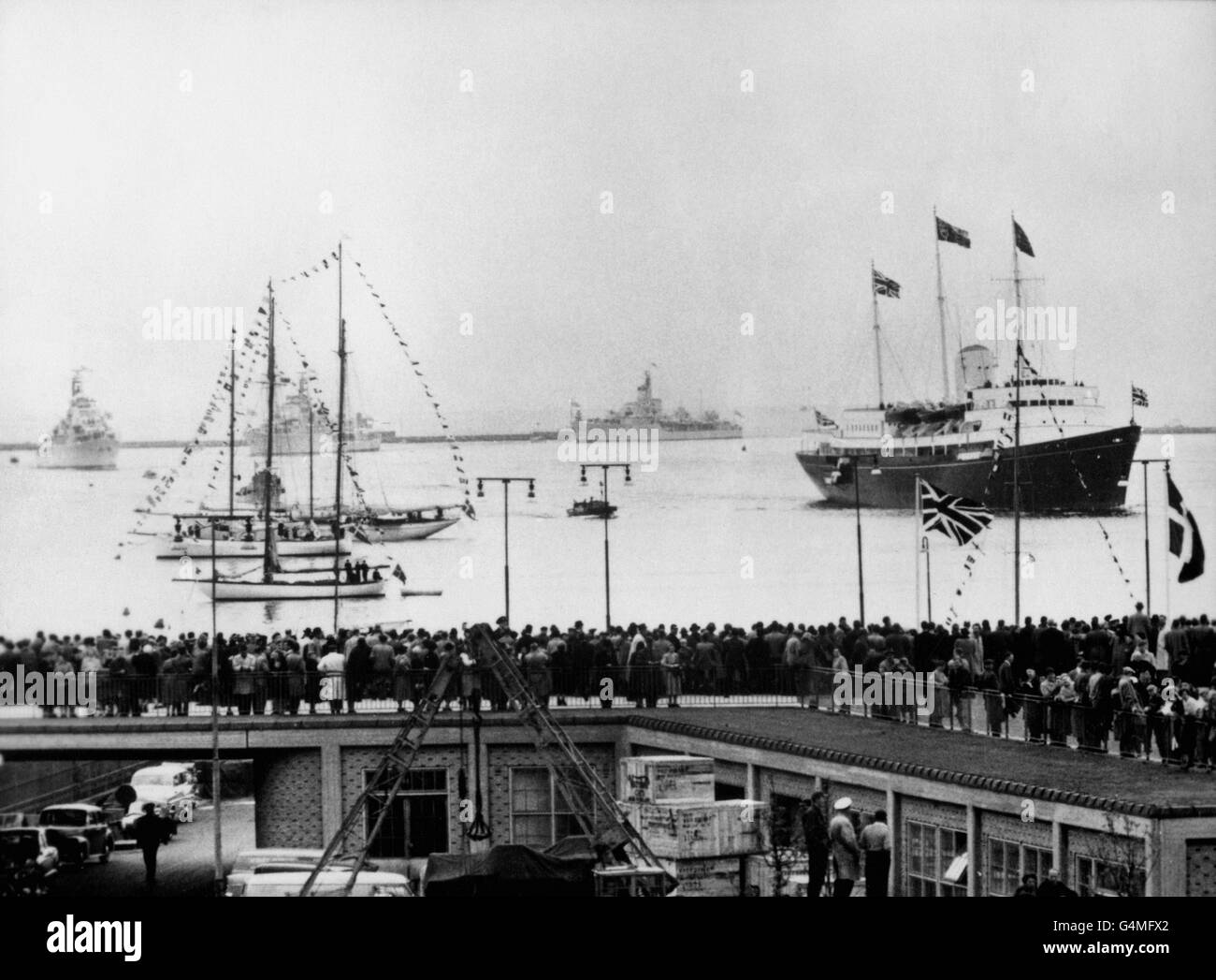 La foule se trouve sur le quai tandis que le yacht royal Britannia navigue dans le port de Copenhague, amenant la reine Elizabeth II et le duc d'Édimbourg à commencer leur visite d'État de trois jours. Banque D'Images