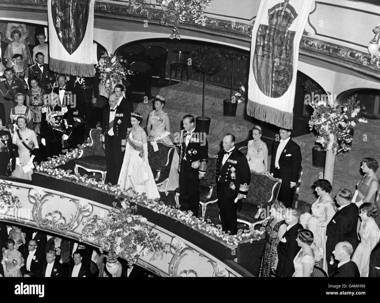 La reine Elizabeth II et le duc d'Édimbourg au Théâtre national d'Oslo, qui assistaient à un gala en l'honneur de leur visite d'État. À gauche de la reine se trouve le roi Haakon, et à droite du duc, le prince héritier Olav. Derrière se trouvent la princesse Astrid, fille du prince héritier, à gauche, et la princesse Ragnhild et son fils, le prince Harald (derrière le roi). Banque D'Images