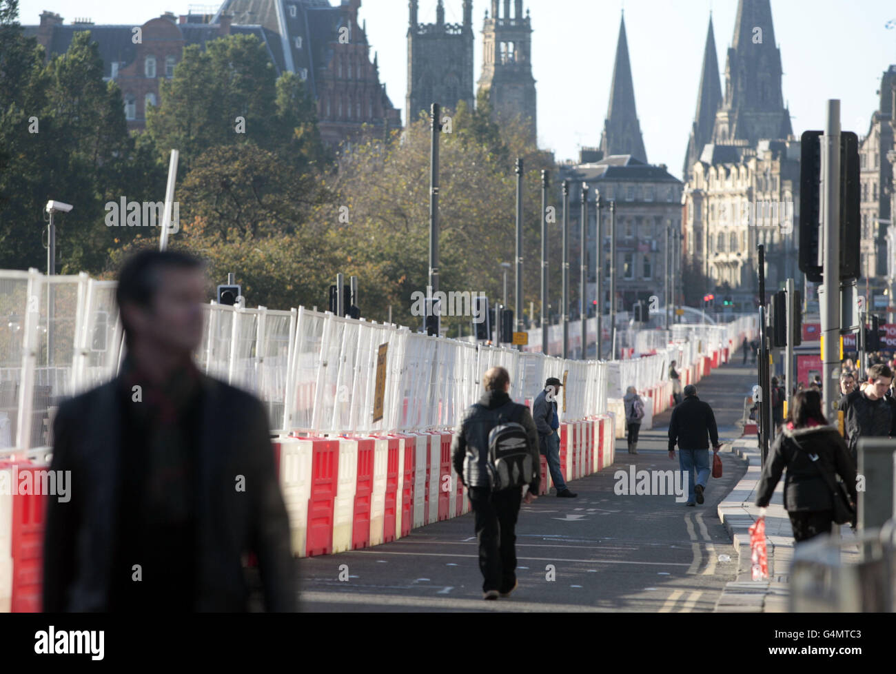 Les clients passent par les tramways de Princes Street à Édimbourg, en construction depuis 2008, mais ont subi des retards et des surcoûts. Banque D'Images