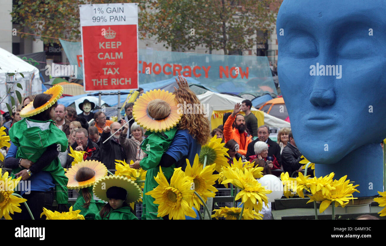 Les personnes voyageant en vague flottante passent devant le camp de protestation anticapitaliste devant la cathédrale Saint-Paul de Londres, lors de la parade du Lord Mayor's Show Parade. Banque D'Images