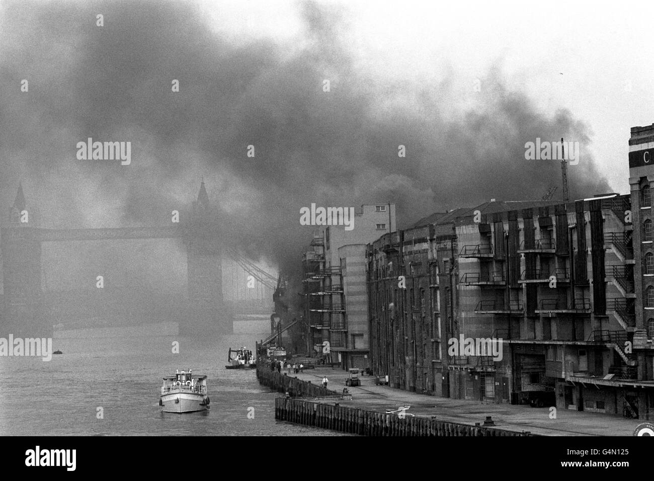 De la fumée épaisse s'échappe d'un immeuble de la rue Tooley sur un feu près de la Tamise, avec Tower Bridge en arrière-plan. Banque D'Images