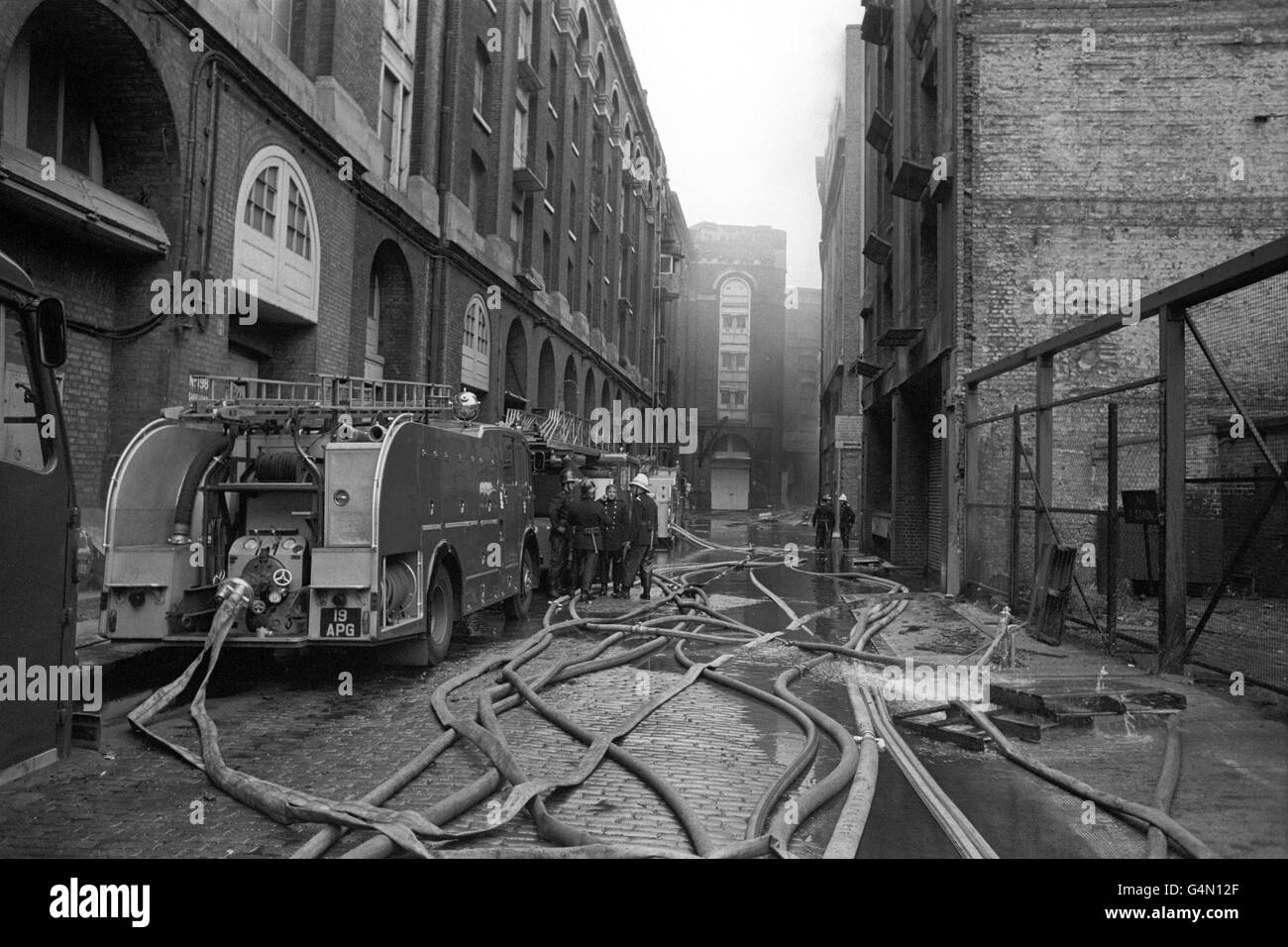Des pompiers travaillent encore sur le dépôt d'entreposage frigorifique désutilisé de Willson's Wharf, Battle Bridge Lane, près du London Bridge, où l'incendie avait fait rage toute la nuit. Huit pompiers ont été blessés dans l'incendie, le plus grand de Londres depuis la Seconde Guerre mondiale. Banque D'Images