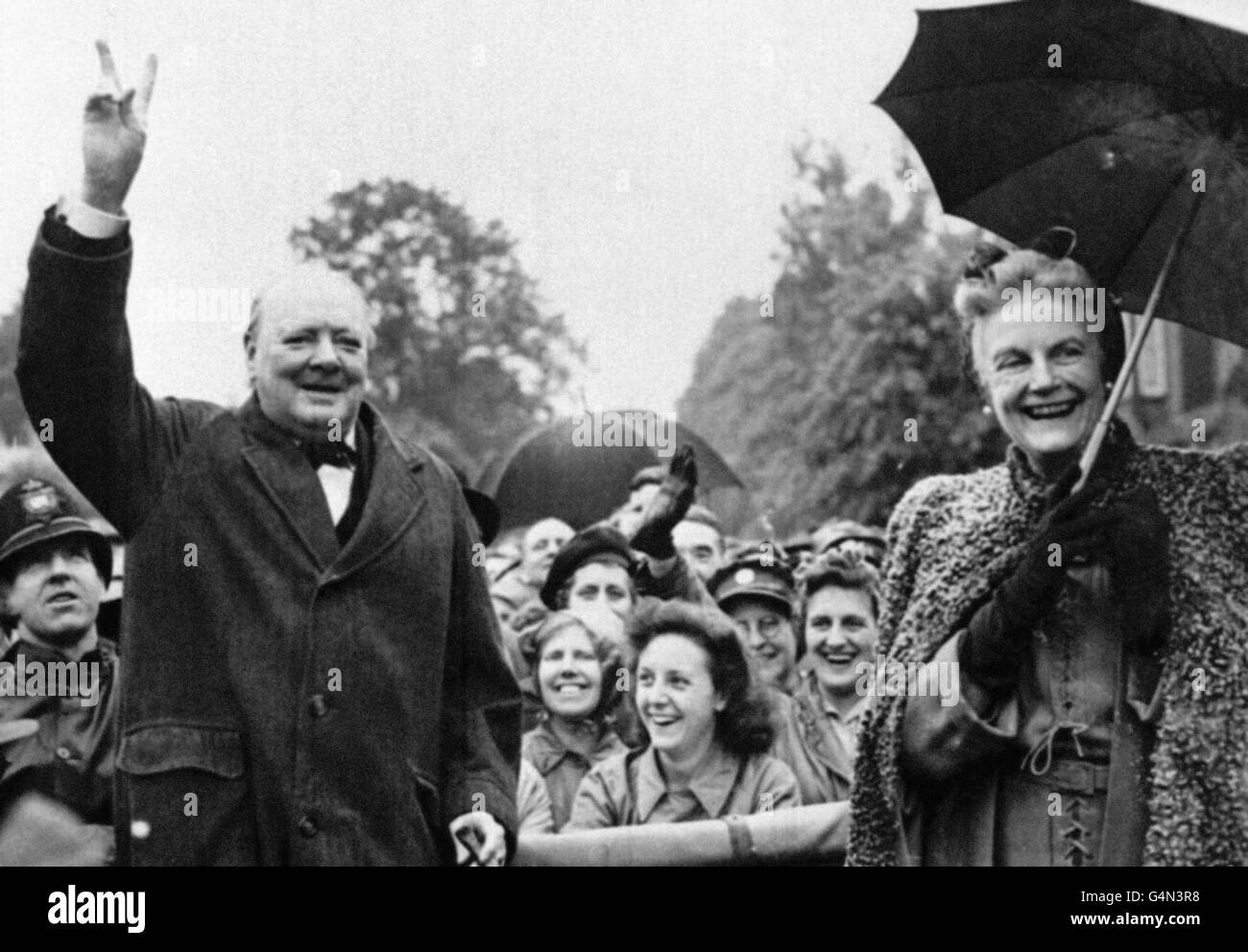 Sir Winston Churchill avec son épouse Clementine. Churchill donne son célèbre signe de victoire. Banque D'Images