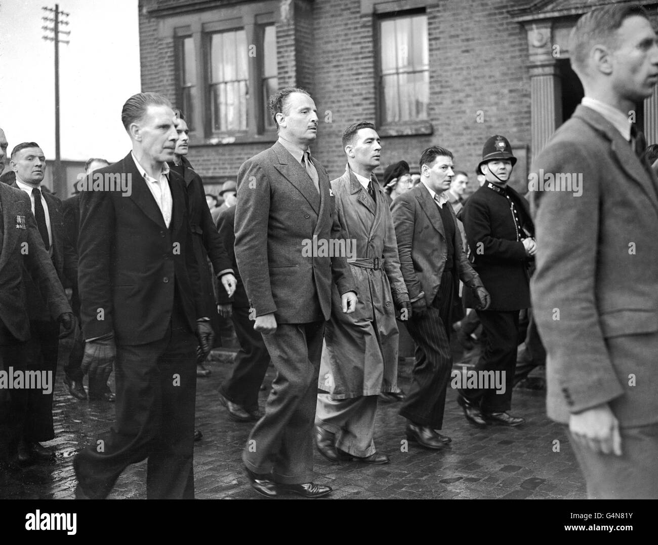 Les partisans de Sir Oswald Mosley tiennent une réunion en plein air le jour de mai. La police s'est mêlée à la foule formée pour entendre des orateurs, entourée de membres du mouvement de l'Union portant la bannière du mouvement, le flash éclair blanc sur fond rouge. Le mouvement de l'Union a été récemment fondé par Mosley et plusieurs ex-membres de l'Union britannique des fascistes et a une perspective plus paneuropéenne car il cherche à amener une super-puissance européenne pour équilibrer la menace de l'URSS et des États-Unis. Banque D'Images